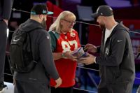 Mamma Donna Kelce delar ut en kaka åt sina söner Jason och Travis några dagar innan den stora finalen. De två möts i finalen. Mamma Donna sitter på läktaren.