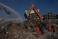 Arbete med grävmaskiner pågår vid byggnader som rasat samman i Kahramanmaraş.