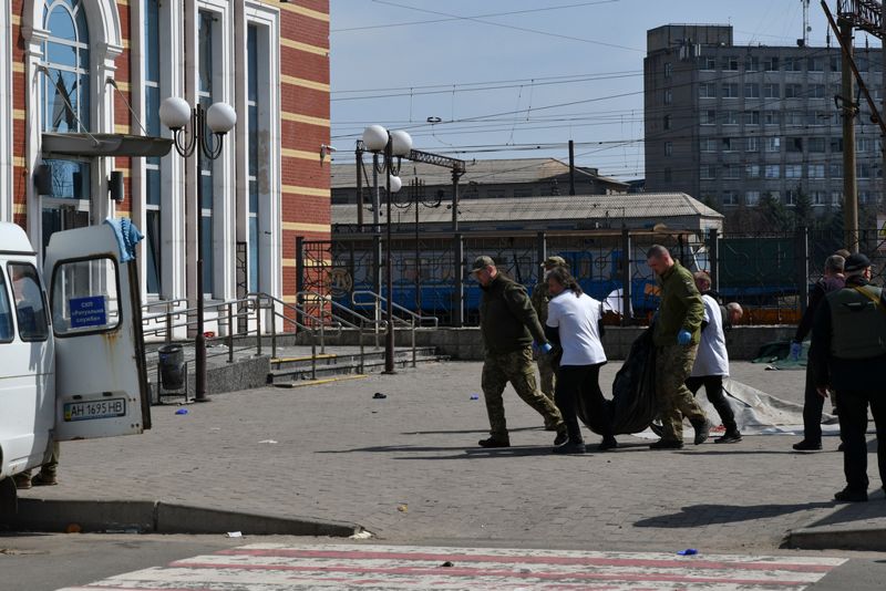 Ukrainska soldater bär undan döda efter attacken mot en järnvägsstation i Kramatorsk i fjol.