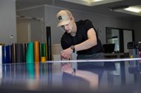 Aabees produktionschef Ola Salminen jobbar med valreklam i företagets hall i Karis – idag får riksdagsvalskandidaterna sina nummer.