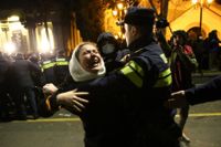 Polis griper en demonstrant under protester utanför Georgiens parlament i Tbilisi den 8 mars.