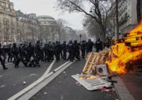 Kravallutrustad polis i sammandrabbning med demonstranter i Paris.