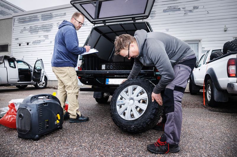 De nio bilarna som ingår i karavanen är av flera olika märken och årsmodeller, de är ungefär 10–15 år gamla. – Bilfirman som sålde bilarna till oss har gjort en lite grundligare service på dem, eftersom de vet att bilarna körs till Ukraina där de kommer att användas i tuffa förhållanden, säger Roope Roine. Mikko Suvinen lyfter in reservdäck på det täckta lastflaket.