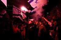 Demonstranter blockerar en motorväg i Tel Aviv-trakten under protesterna natten till måndagen.