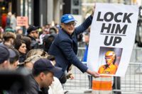 En demonstrant håller en skylt utanför Trump Tower i New York på måndagen.