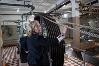 Nina Häggroth, här vid ett av de stora svänghjulen, säger att maskinerna imponerar på dem som besöker eller tittar in i rummet.