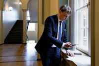 Otto Andersson tar en bild av sin fullmakt innan det är dags att visa upp den för riksdagens generalsekreterare Maija-Leena Paavola.