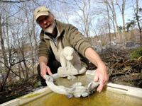 Skulptören Janne Henriksson och en av hans fontäner som samtidigt är ett fågelbad.