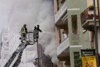 Brandmän i Milano kämpar mot lågorna som spridit sig till en intilliggande byggnad.