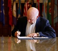 Greg Gianforte skriver under lagen.
