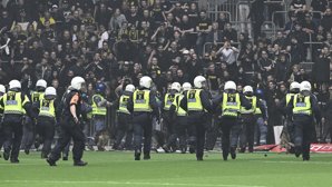 Poliser på planen motar bort AIK-supportrar som försökte ta sig in på planen i Stockholmsderbyt mot Djurgården.