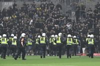 Poliser på planen motar bort AIK-supportrar som försökte ta sig in på planen i Stockholmsderbyt mot Djurgården.