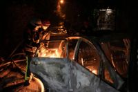 Räddningstjänsten i Kiev släcker en brand som brutit ut i ett fordon under nattens ryska attack mot huvudstaden.