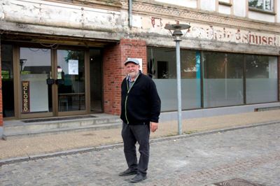 Café Møltrup åbnede i Vildbjerg i 2016. Facaden og butikken blev renoveret og malet i antik-farver. Stedet drives stadig i den socialøkonomiske ånd, som kan genkendes fra Møltrup Optagelseshjem. Her er Ebbe Larsen fotograferet foran bygningen før istandsættelsen. Foto: Herning Folkeblad