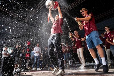 Henrik Dalsgaard hiver DM-trofæet i vejret, mens Oliver Sørensen, André Rømer og flere andre sprøjter med champagne.