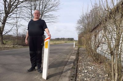 For Kirstine og Kurt Kjær kommer de store lastbiler og landbrugsmaskiner meget tæt på huset. Allerhelst vil de flytte, for de frygter både rystelser i huset, samt lys og lydforurening i stuen lige på den anden side af muren.