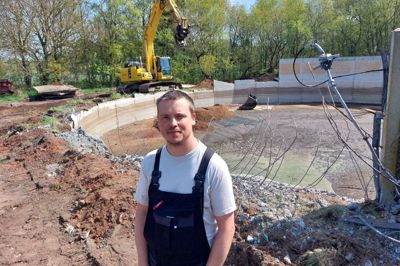 Simon Breinholt fotograferet for et par uger siden - ved resterne af den 23 år gamle gylletank han skal fjerne, fordi 165 kvadratmeter af den ligger inde i en fredskov. Tanken er nu blevet fjernet, men den unge landmand får ikke erstatning.