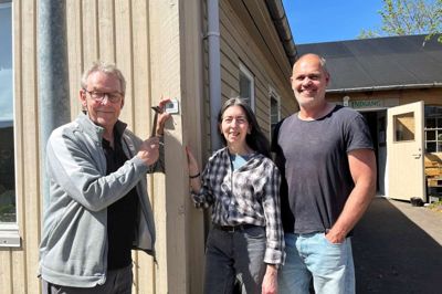 Fra venstre Peer Thøgersen, Grethe Bremer og Martin Rud med en af de QR-koder, som en række huse i Gl. Rye får påsat, så man kan læse om deres historie via sin smartphone. De tre er alle med til at lave Aktuelt, Gl. Ryes beboerblad, hvor historierne har været bragt.