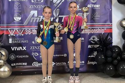 Lise (t.,v.) og Emily Lund Kjær med medaljer og pokaler, efter at pigerne fra Kibæk Cirkusklub deltog i verdensmesterskaberne i Litauen.