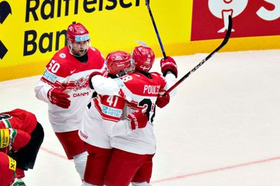 Blue Fox-spillerne Mathias Bau Hansen (t.v.) og Morten Poulsen (t.h.) omfavner Jesper Jensen Aabo, der har scoret til 3-2.