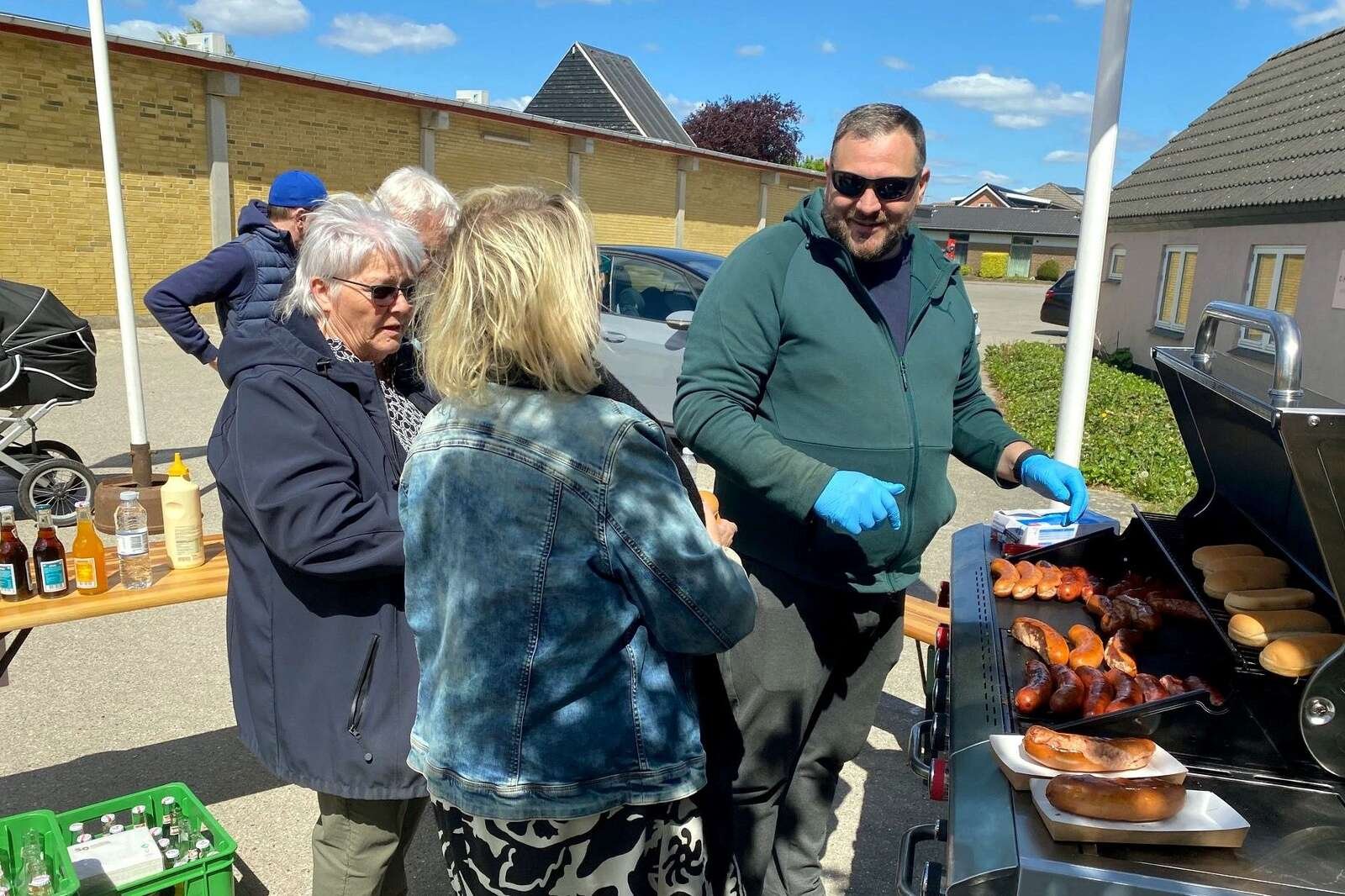 Brugsens bestyrelse grillede pølser til de tilskuere, der nød at sidde i solen og følge Søren Brynjolfs arbejde med skulpturerne. Privatfoto