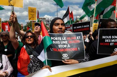 En kvinde holder et skilt med ordene "Jeg bærer hijab, jeg er dronning, stop islamofobi" ved demonstrationer i Paris 11. maj. (Arkivfoto).