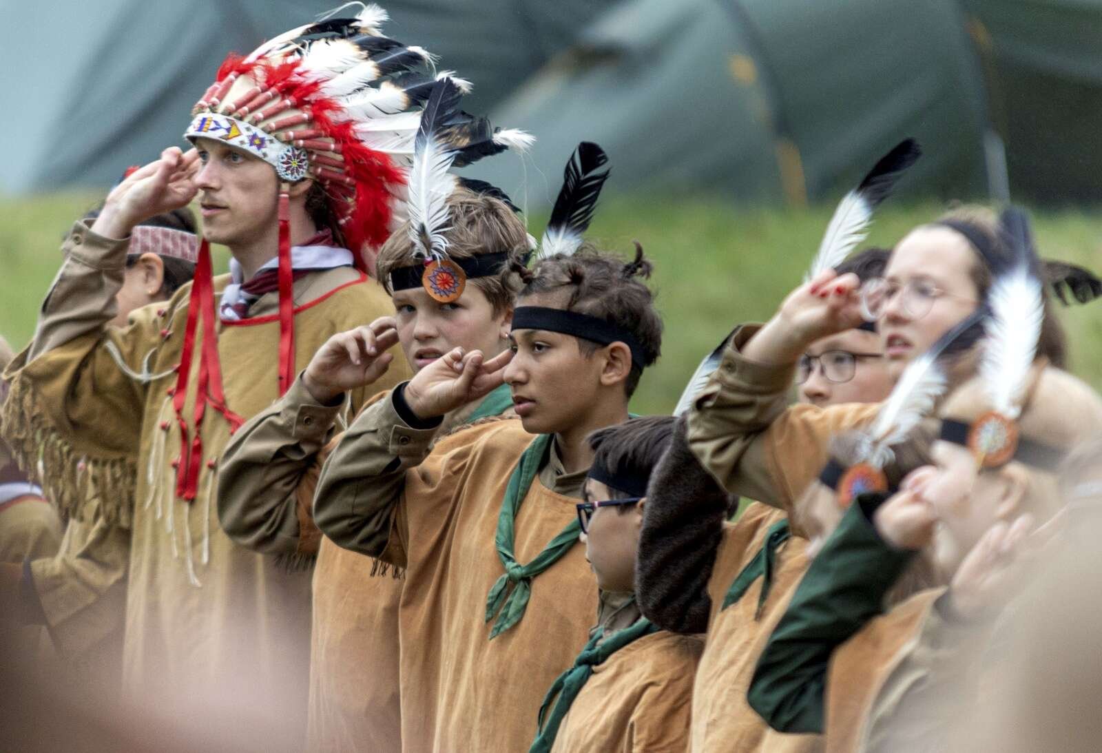 Også indianere excellerer i spejdernes velkendte hilsen og kampråbet »tjikkerlikker, tjikkerlikker, tjauv, tjauv, tjauv«.