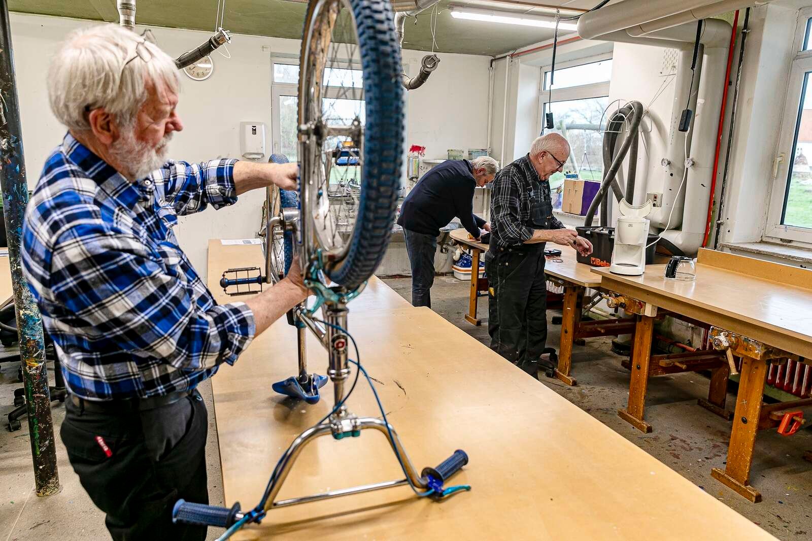 Lars Bøjesen har fået en cykel ind at reparere på, og i baggrunden er en kaffemaskine kommet under kærlig behandling af Ejner Tranberg.