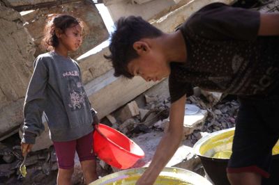 Palæstinensiske børn skraber skålene for at få en portion mad ved et uddelingssted i Gaza By fredag. Efter mere end 20 måneders krig advarer organisationer om, at Gazastribens godt to millioner indbyggere risikerer en situation, der ligner hungersnød.