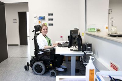 22-årige Cecilie Marie Clausen arbejder som lægesekretær på Regionshospitalet Gødstrup. Med sygdommen cerebral parese er elkørestolen en fast bestanddel i hendes liv, men hun er fast besluttet på at se muligheder frem for begrænsninger - hun vil have noget ud af sit liv. Foto: Tom Laursen