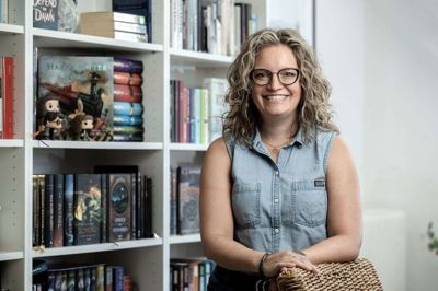 Fantasyforfatter Lene Dybdahl synes, det vil være en god idé at få papirbøger og stilehæfter tilbage i folkeskolen. - Jeg er ikke maskinstormer, men jeg synes, det er vigtigt at bruge rigtige bøger, når man skal lære noget. Hvis jeg læser en bog på Kindle, glemmer jeg den hurtigere bagefter. Men en fysisk bog - det er mere taktilt, og hvis jeg skal finde et bestemt citat, der stod i bogens første halvdel, så er det nemmere at bladre i en fysisk bog, siger hun. I forbindelse med udgivelsen af »Fangen fra Ulvmarken« holdt forlaget Tellerup releasefest på Sophiendal Slot ved Skanderborg for 100 af de 400 kursister på Lene Dybdahls online-skrivekurser. Her kunne man købe bogen i en specialudgave med håndkolorerede sider i en boks med postkort med beskrivelser af stederne i bogen og en pin med en skorpion som motiv. Skorpionen er logoet for serien, der har titlen Magismondo, og hvor »Fangen i Ulvmarken« er den første. Bogen er blevet sammenlignet med forfatteren Sarah J. Maas’ bestseller-fantasybøger. Hende er Lene Dybdahl kæmpefan af, så hun er selvsagt stolt over sammenligningen. Foto: Chresten Bergh