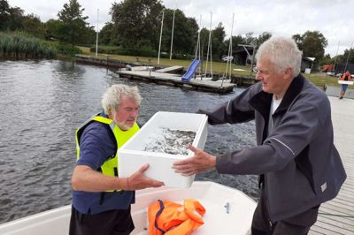 Henning Feldborg tager imod en kasse med små ål fra Klaus Rude ved årets udsætning af blankål, som Fiskeri- og Bredejerforeningen for Sunds Sø står for. Ålen er fredet, men det er lovligt at fange ål i ferskvand fra 1. august til 15. oktober. FOTO: JESPER WIND