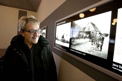 Inge-Lise Sterup foran den historiske billedfrise i den nyrenoverede lillesal i Havredal Kultur- og Forsamlingshus. Foto: Morten Marboe