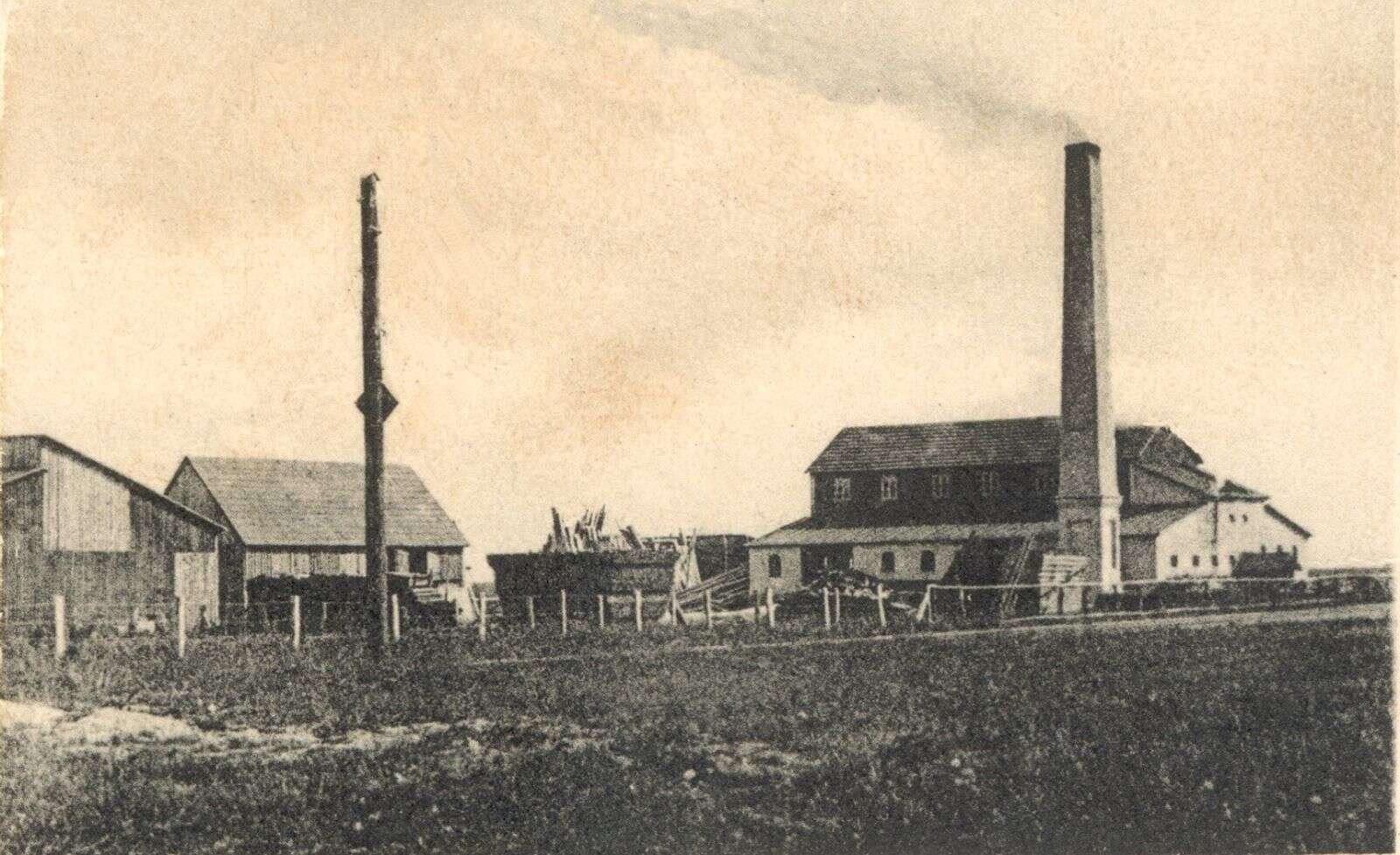 Her ses det oprindelige savværk inden branden i 1926. I den store bygning til højre var der både savskæreri og snedkeri, og i loftetagen var der bl.a. et stort lager. Under bygningen stod en dampmaskine, som leverede kraft til maskinerne, og som var årsag til branden. Foto: Karup Egnsarkiv