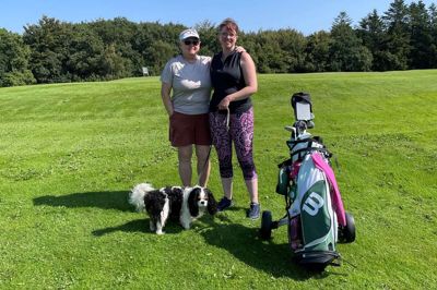 Michelle (th) har servicehunden Alfie med på golfbanen i Tange. Til venstre ses Jytte Bak Hansen, der er tovholder på kurset Kvinder og Golf. Privatfoto