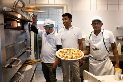 Gobi Sivanthan (i midten) åbnede for nylig Thamili Pizza & Tamilsk Mad på Gl. Landevej, hvor man på menuen både finder tamilske retter samt pizza og grillmad.