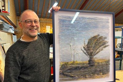 Bjarne Nielsen har valgt, at værket her, som er et foto skåret i fine strimler og sat op på tyl, skulle have en blå ramme. Kunstneren er Anne Mie Bak.