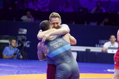 Turpal Bisultanov får en sejrskrammer af den danske landstræner, Szymon Kogu, efter at herningenseren har besejret tyrkiske Cengiz Ali i suveræn stil i semifinalen ved VM i Beograd. Foto: Danmarks Brydeforbund