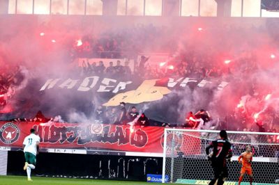 10.284 tilskuere var med til at sætte gang i derbyet mellem FC Midtjylland og Viborg. Det skete blandt andet med pyroteknik, bannere og flag - som her bag målrammen på CC Contractor-tribunen. Foto: Tom Laursen