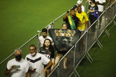 Mandag aften var der en kø på mere end én kilometer uden for Vila Belmiro stadionet i Santos. Her ses flere fans, efter at de var kommet ind på stadion, hvor køen fortsatte hen til Pelés kiste.