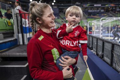 Sarah Iversen stråler af glæde med sønnen Elliot i armene under EM 2022 i Slovenien. Livet som mor har styrket hendes planlægningsevner og lært hende at komme hurtigere og bedre videre fra sportslige skuffelser. Foto: Tariq Mikkel Khan/Ritzau Scanpix