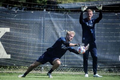- Jeg har trænet på livet løs og holdt mig skarp. Jeg har faktisk også været med til alle kampe, for Midtjylland tager altid tre målmænd med. Selvom det ikke ligner, at jeg har været inde omkring det, føler jeg, at jeg har været en del af det. På den måde har jeg været tæt på truppen, siger Oscar Hedvall, der her ses bag førstekeeper Jonas Lössl. Foto: Chresten Bergh