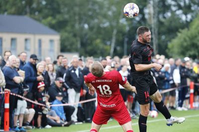 FCM-anfører Henrik Dalsgaard når højest i en duel med den tidligere FCM-spiller Jesper Juelsgård i tirsdagens testkamp, som havde trukket mange tilskuere til i Ikast. Foto: Chresten Bergh