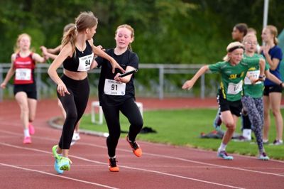 Mynthe Støjberg Zink fra Herning GF rækker depechen videre til klubkammeraten Sofiia Gorpenko, der sprinter sejren hjem til Herning i 4x80 meter for 12-13-årige mixhold. Foto: HGF AM