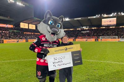 Maskotten Lupus overrækker den store check til 13-årige Villads Martinus Bank Hansen, der stråler efter sin fuldtræffer i »Halftime Hero«. Foto: FCM
