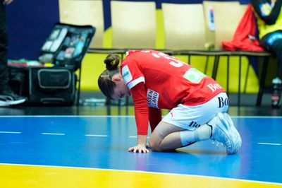 Emma Friis knækker sammen på gulvet i skuffelse, da Henny Reistads langskudsperle rammer nettet til 29-28 i sidste sekund af den forlængede spilletid.
