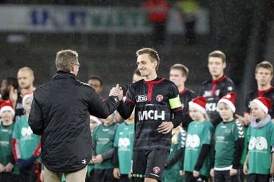 Danny Olsen (t.h.), der her får afskedsblomster af FCM-direktør Claus Steinlein i december 2013, nåede 199 kampe for Ulvene fra 2007 og seks sæsoner frem.