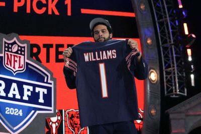 Caleb Williams viser sin nye spillertrøje frem efter at være blevet valgt i NFL-draften natten til fredag dansk tid.