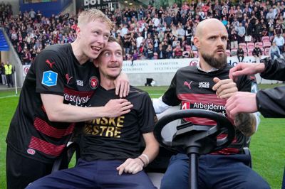 Kristian Bach Bak var chauffør for Kristoffer Olsson, der blev kørt rundt på banen efter guldkampen. Her får han en krammer af målscorer Ole Brynhildsen. Pokalen var med i vognen.