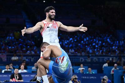 Turpal Ali Bisultanov jubler efter bronzesejren, mens David Losonczi sidder knækket tilbage.